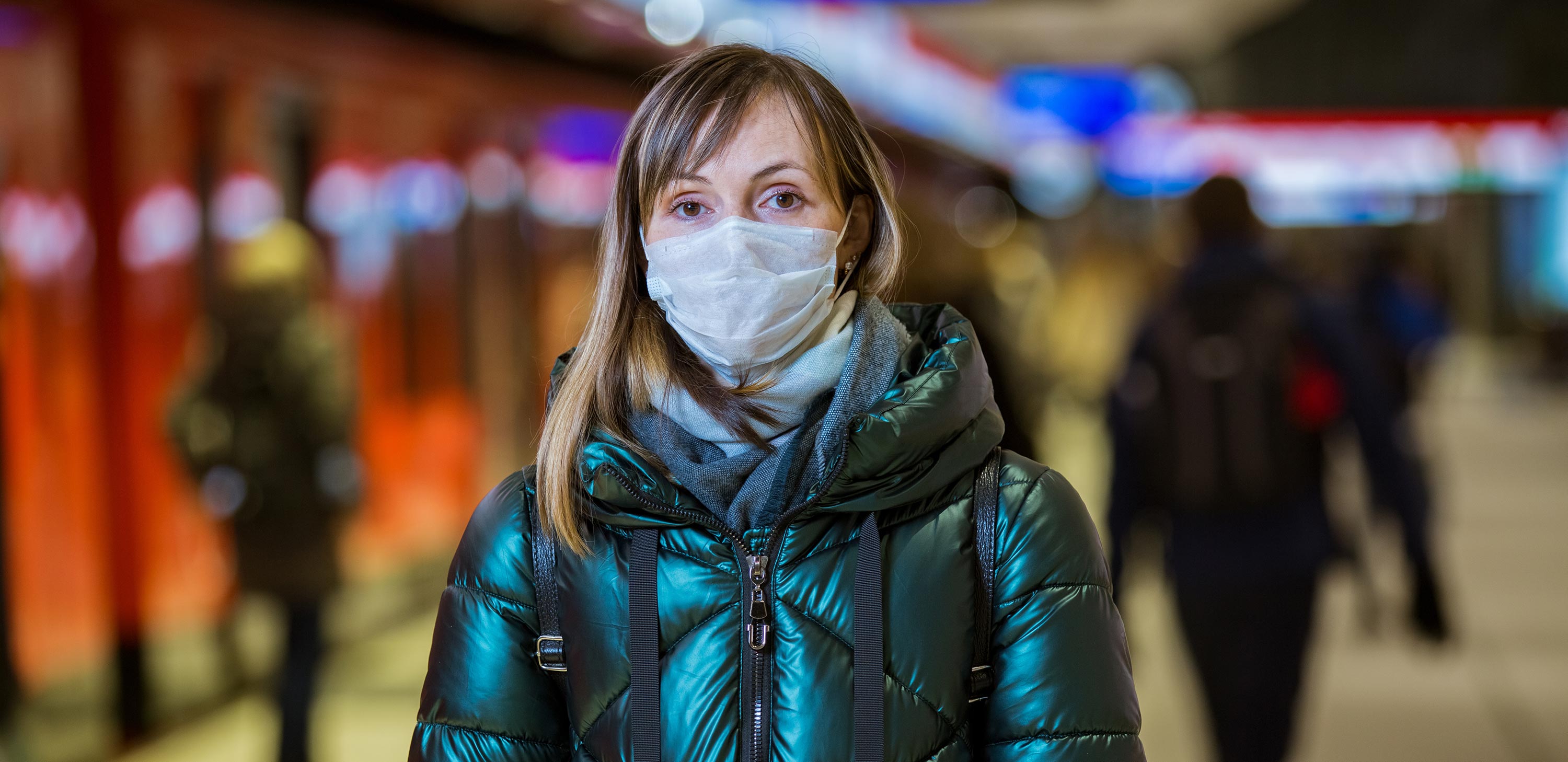 Woman in winter coat wearing pandemic mask