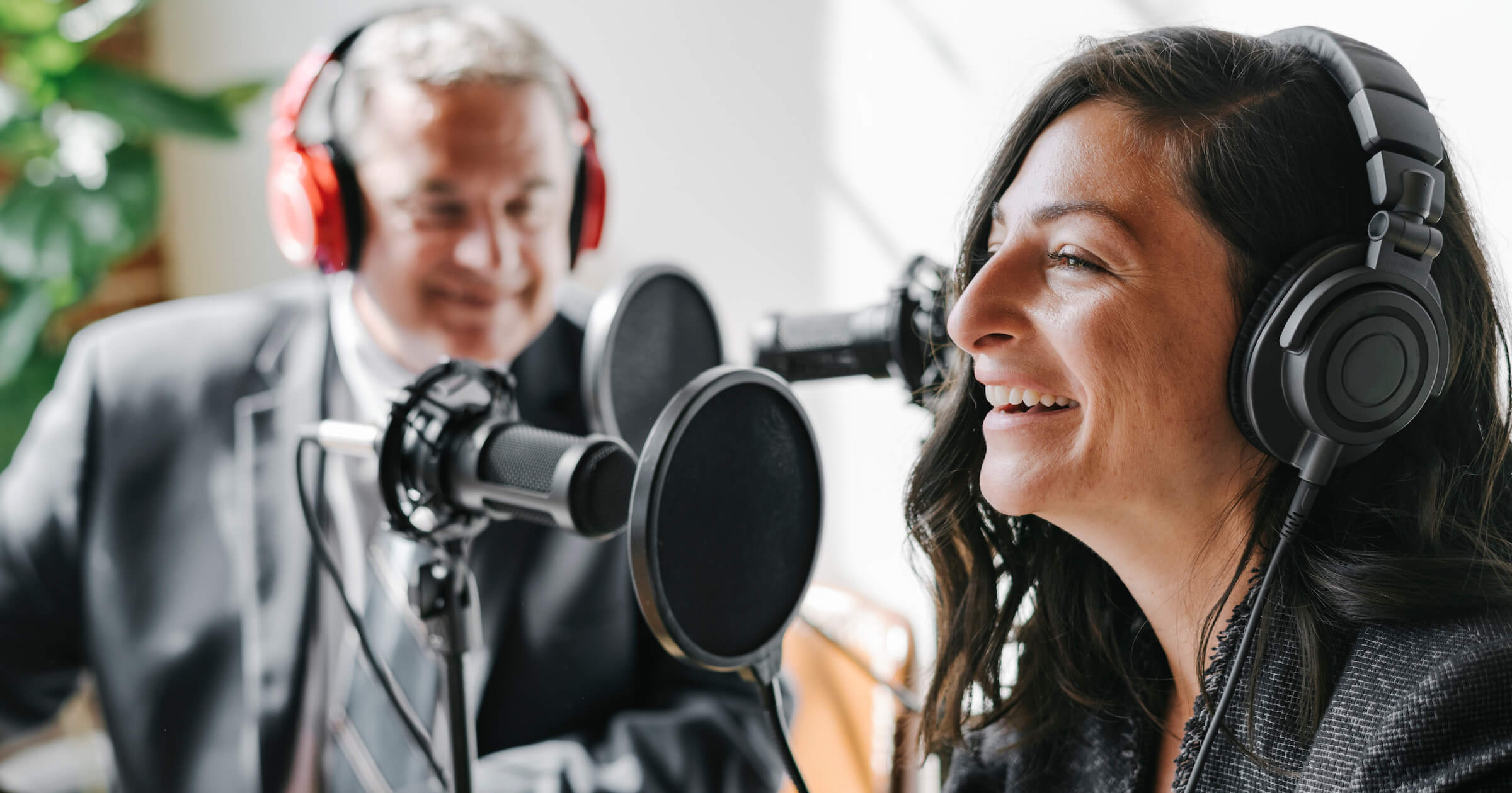  Woman and man talking on mics for a podcast
